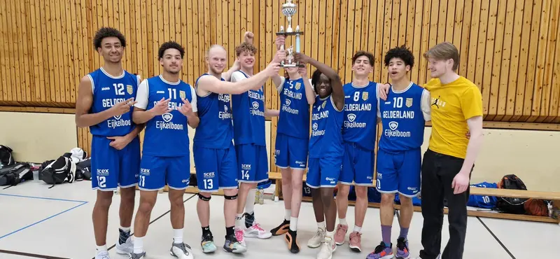 United Basketball players cheering as they lift a trophy in Berlin.