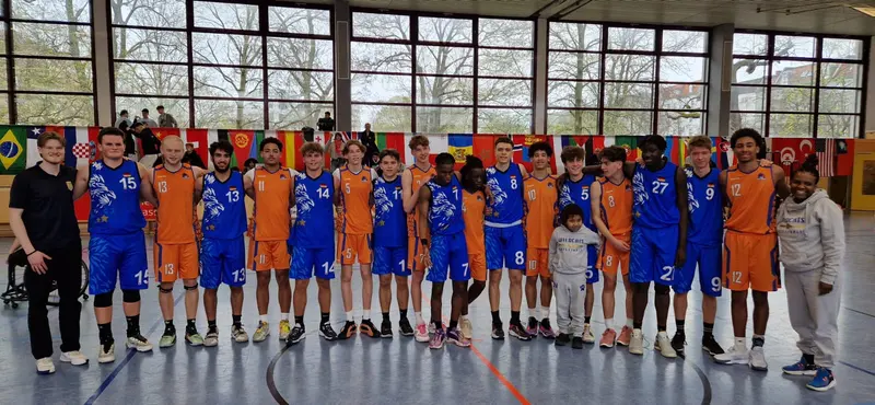 United Basketball players in blue together with their opponents in orange after a game in Berlin.