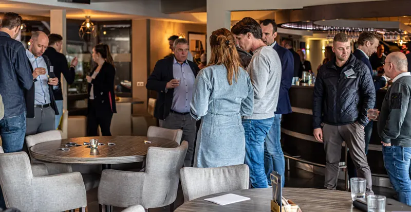 Business guests chatting over drinks during a reception at De Kooi