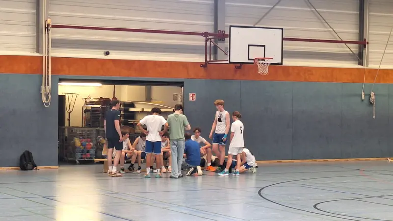A United Basketball youth team gets instructions from the coach during a time-out in Leer.