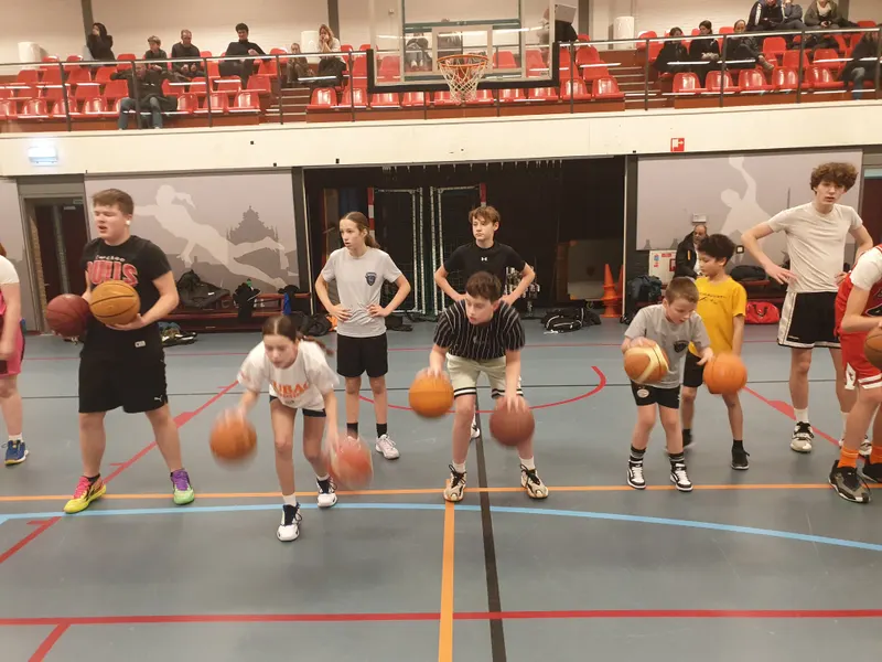 Jeugdspelers oefenen dribbelen tijdens een regiotraining bij een vereniging