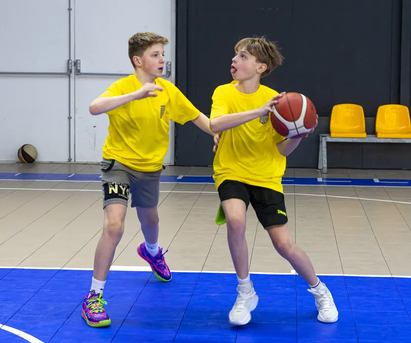 Twee jongens spelen één tegen één tijdens een clinic