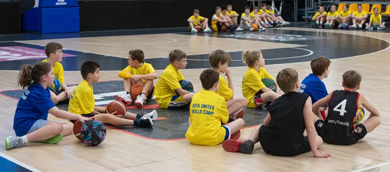 Een groep kinderen zit in een kring op het veld en luistert naar de uitleg