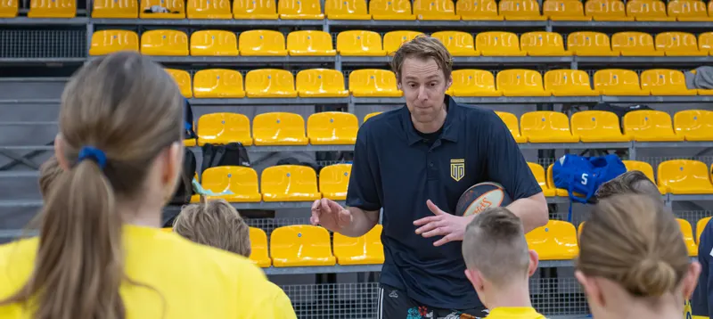 Een speler van United legt een oefening uit aan een groep kinderen