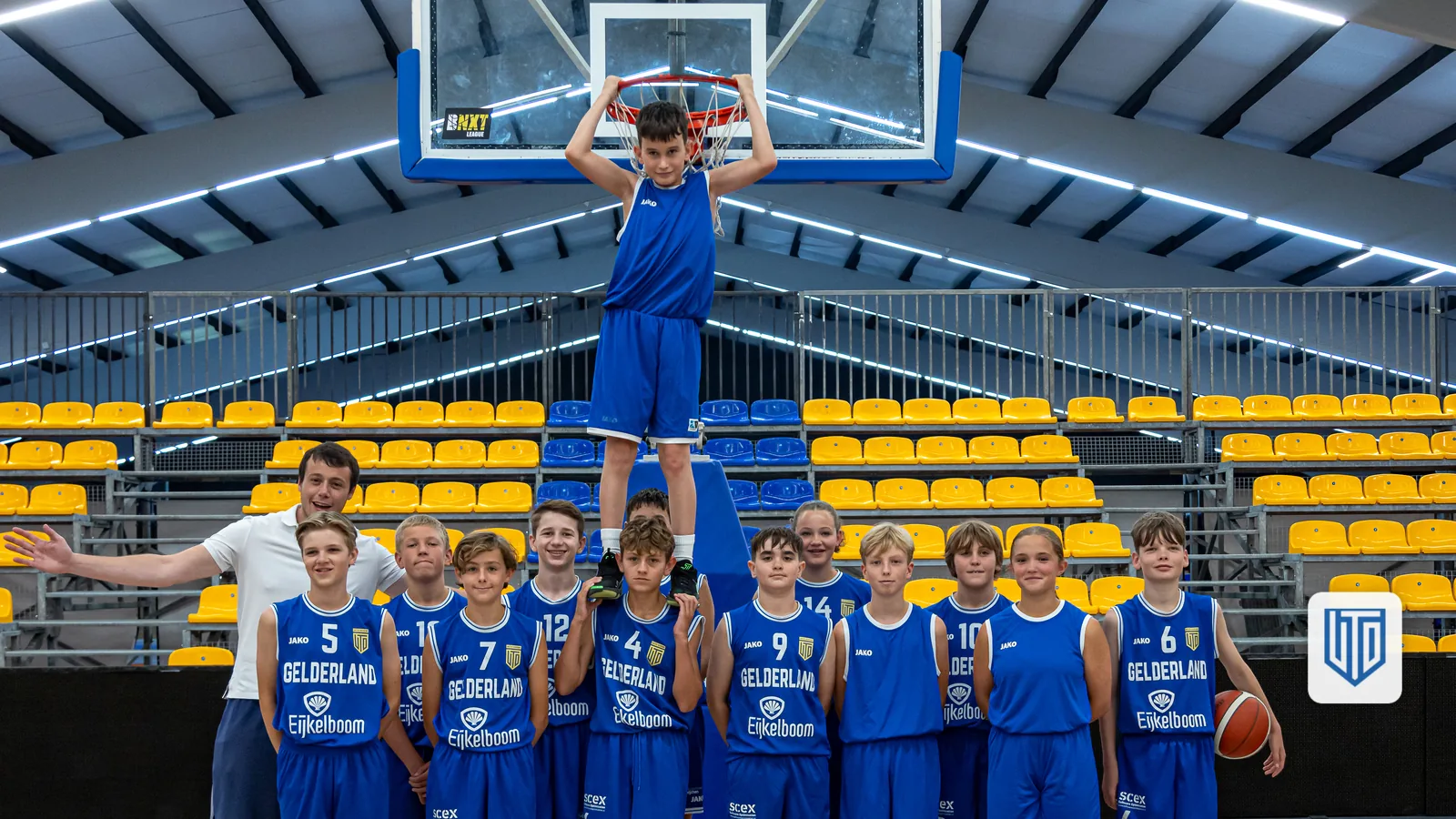 Jeugdteam van United in blauwe tenues poseert speels in de sporthal (standaardfoto ter illustratie, niet gerelateerd aan dit artikel)