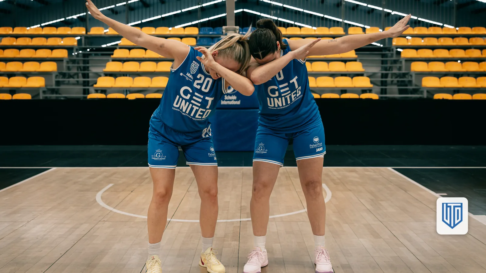 Twee speelsters in GET United-tenue staan rug aan rug op het veld (standaardfoto ter illustratie, niet gerelateerd aan dit artikel)